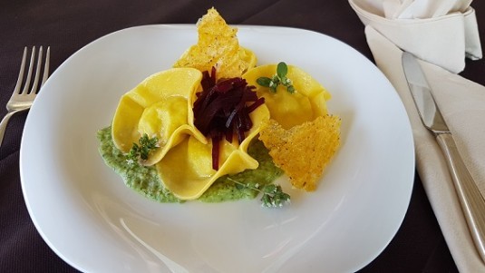 Ravioli ripieni di baccalà su vellutata di zucchine e chips di polenta